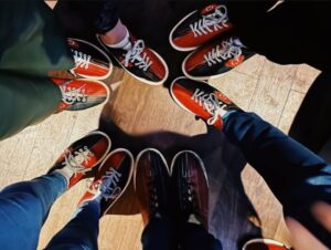 Image of feet in bowling shoes arranged in a circle