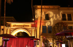 NBCC's Les Girls event at Paramount Studios, Hollywood. The Paramount Pictures arch is visible, and the Les Girls logo is projected on a studio building.